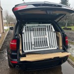 Šuns transportavimo narvas BMW X5 automobilio bagažinėje. Šuns transportavimo boksas